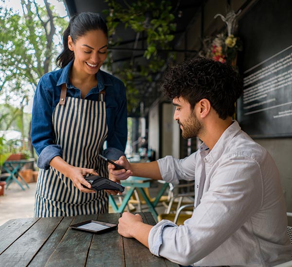 Man using his phone to make a payment at a restaurant.