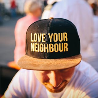 Man wearing a love your neighbor hat
