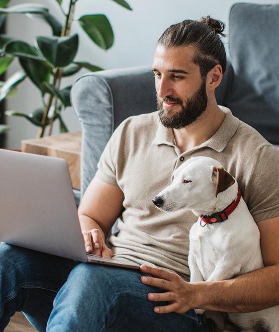 Man using his laptop at home with his dog