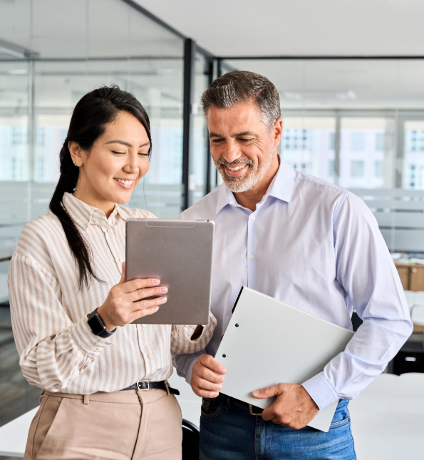 man and woman in office reviewing tablet