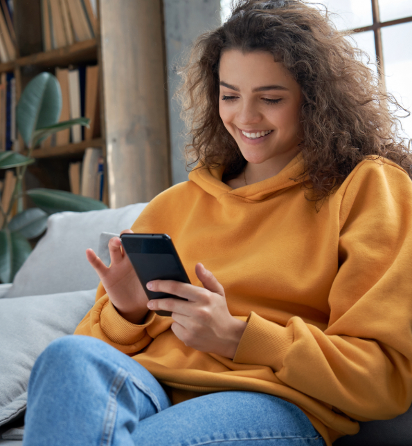 woman sitting on couch using cellphone