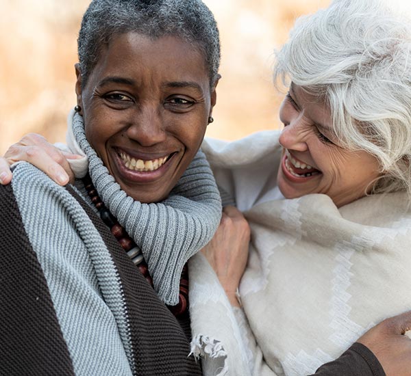 Two mature females hugging.