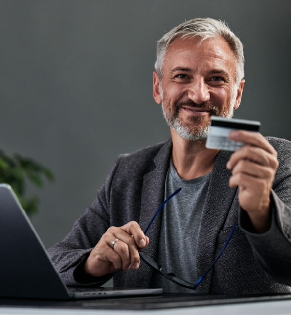 man in gray suit holding credit card